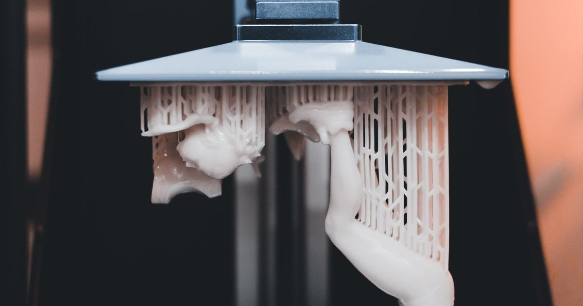A resin 3D printer actively printing a dental appliance, close-up view.