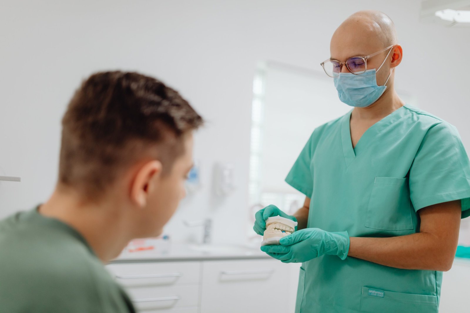 Dentist explaining a treatment plan to a patient during a dental consultation.