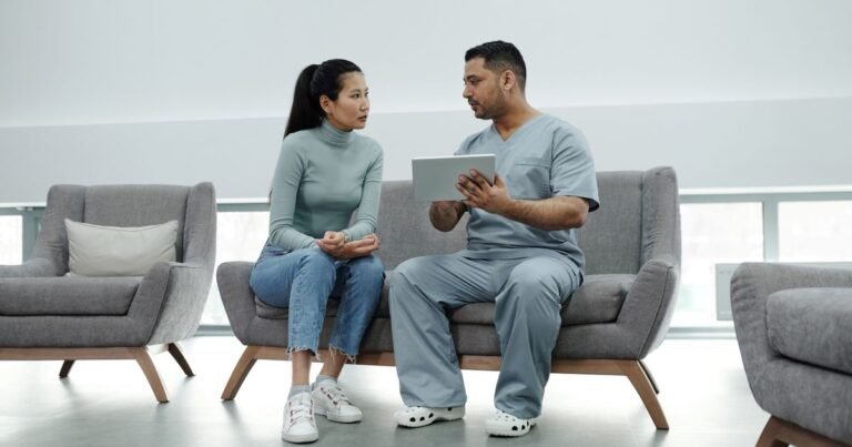 Dentist and patient sitting together, reviewing a digital treatment plan on a tablet in a modern clinic.