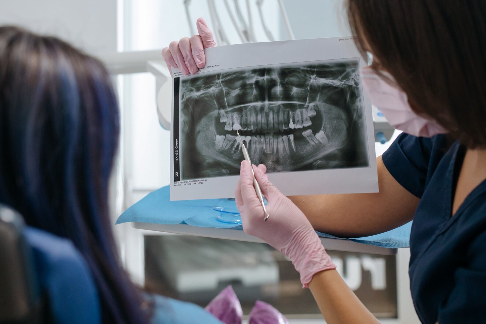 A dentist showing a dental X-ray to a patient and explaining the results and treatment options