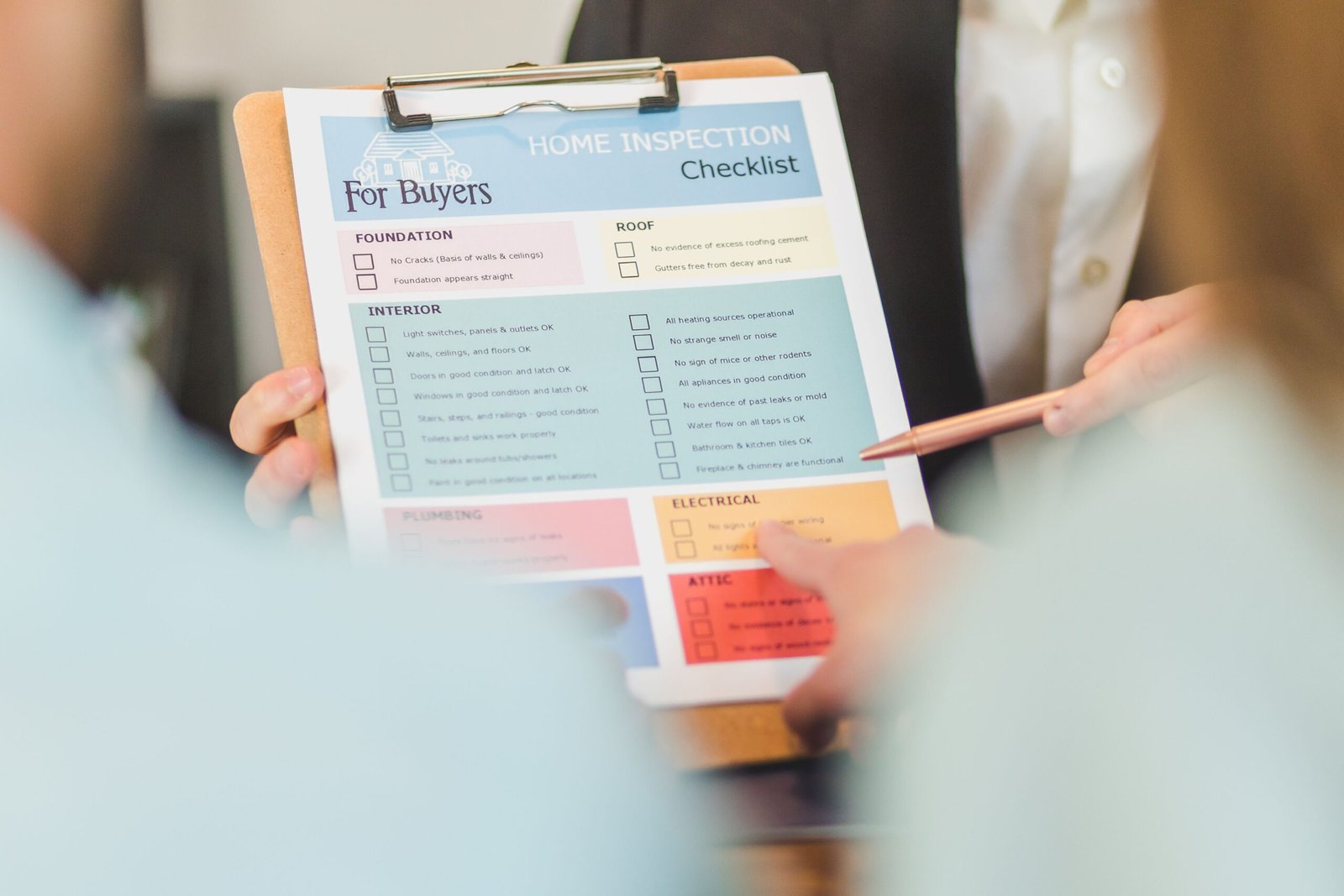 Close-up of hands holding a clipboard with a checklist and pen, reviewing items before making a decision