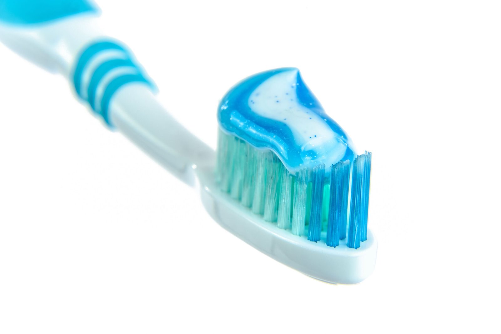 A close-up of a toothbrush with toothpaste applied to the bristles