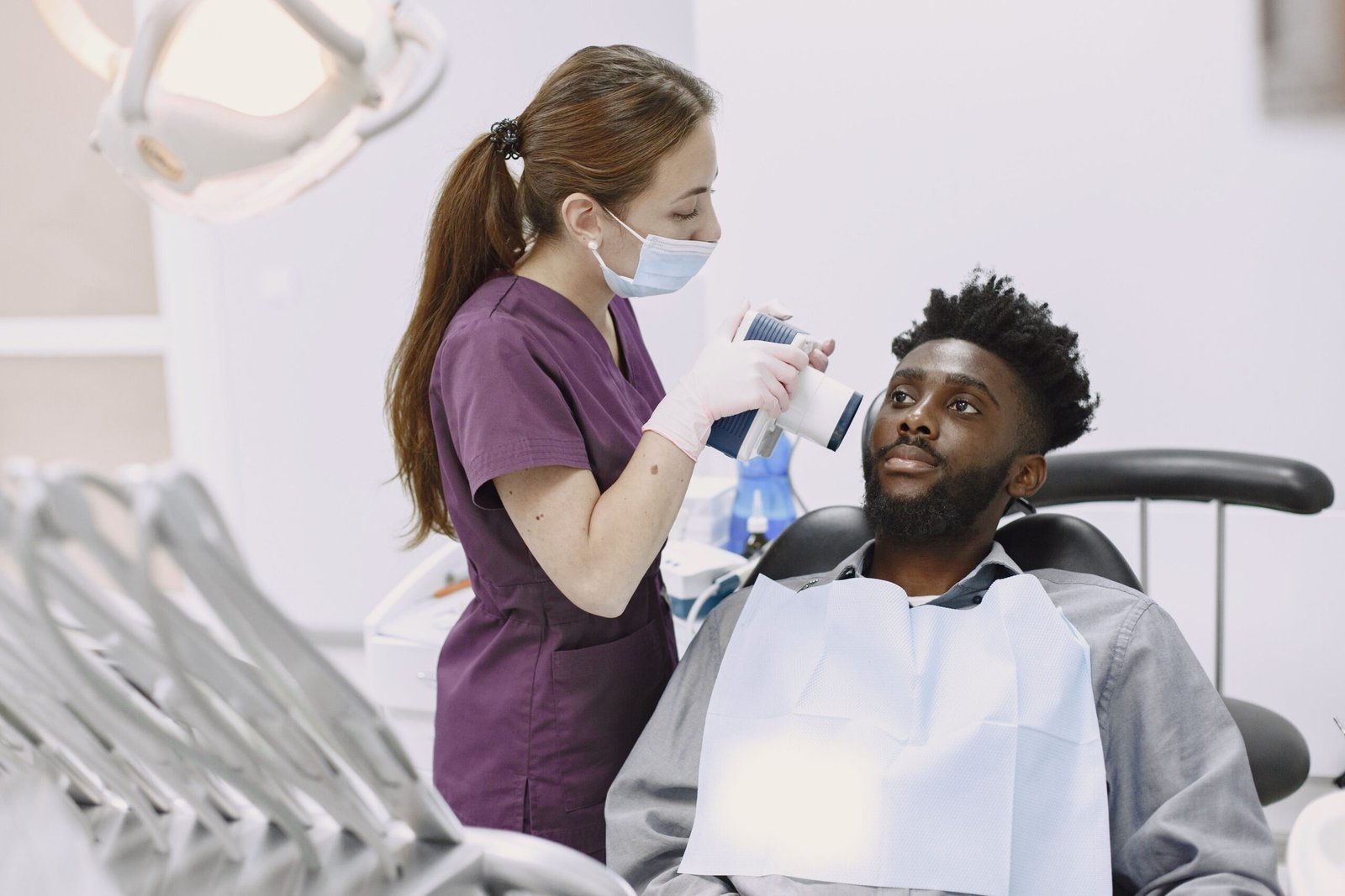 A dentist conducting a dental examination using modern equipment on a patient
