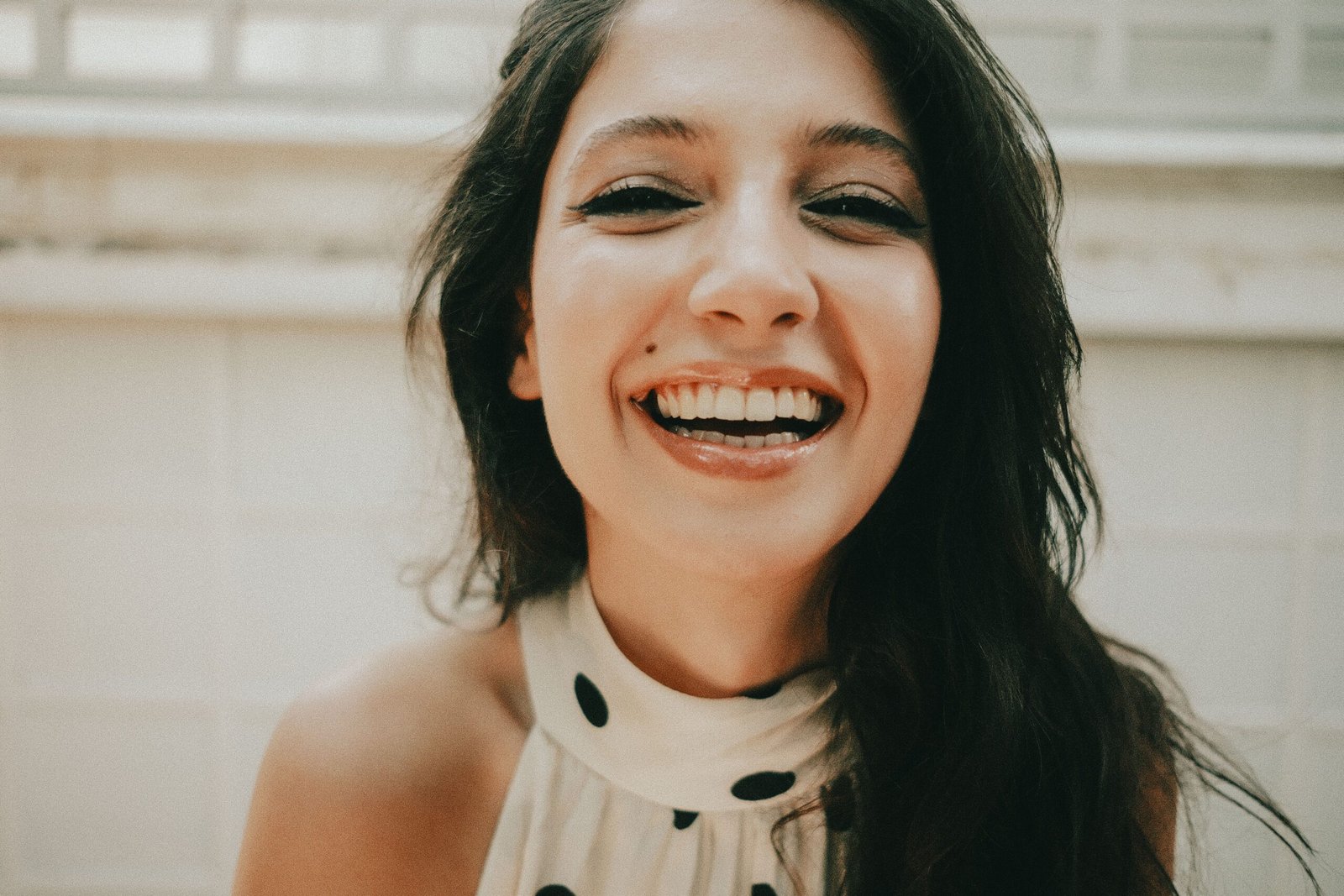 A young woman with a joyful expression and a bright smile in a close-up indoor portrait