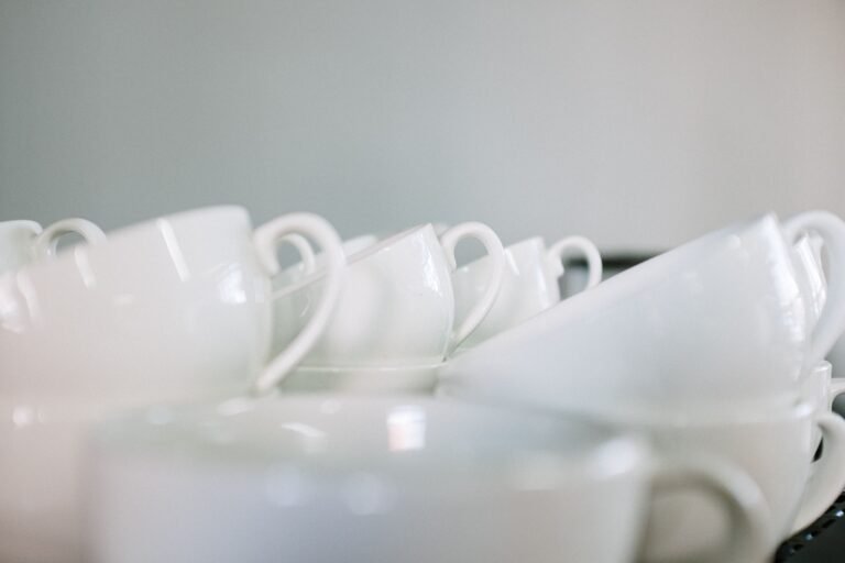 Stacked white coffee cups arranged as a minimalist still life in a café.